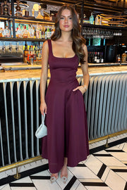 Woman in a burgundy dress standing in a bar setting