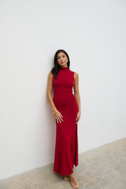 Woman wearing a red dress against a white wall