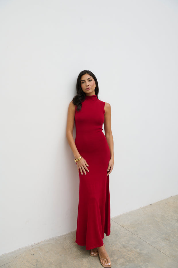 Woman wearing a red dress against a white wall