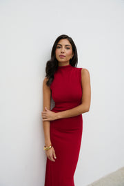 Woman wearing a red dress against a white wall