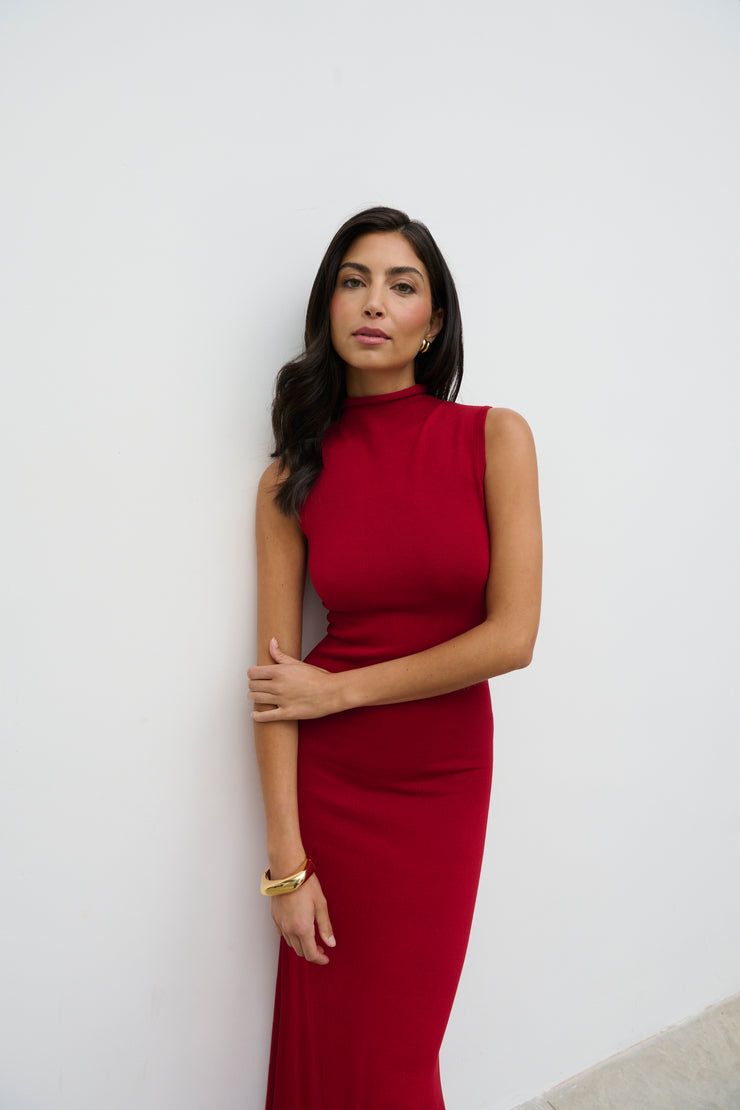 Woman wearing a red dress against a white wall
