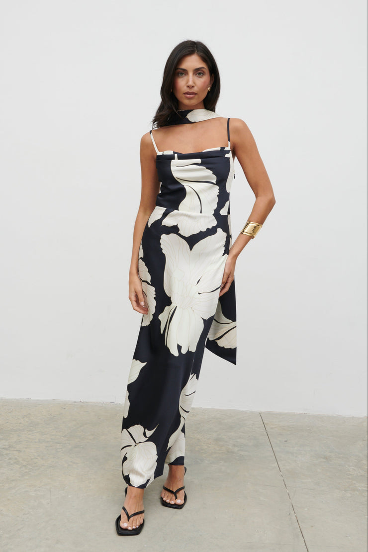 Woman wearing a black and white floral dress against a plain background