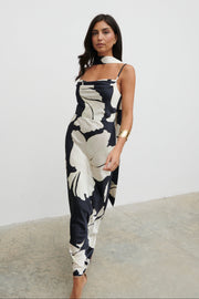 Woman wearing a black and white floral dress against a plain background