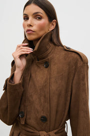 Woman wearing a brown coat with a plain background