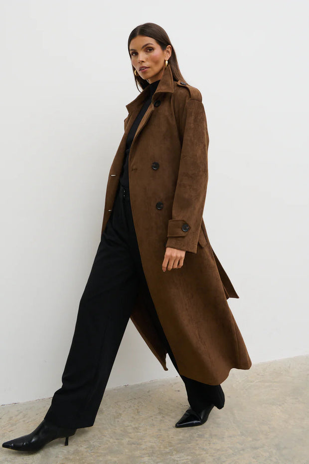 Woman wearing a brown coat against a white background