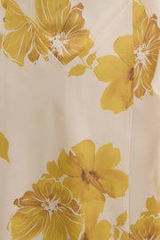 Close-up of a fabric with large yellow floral patterns on a beige background