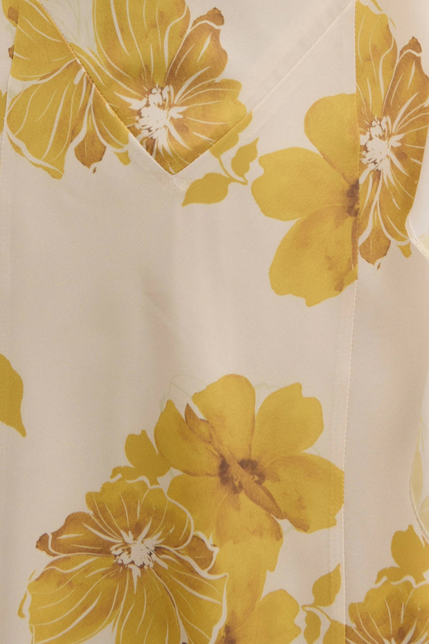 Close-up of a fabric with large yellow floral patterns on a beige background