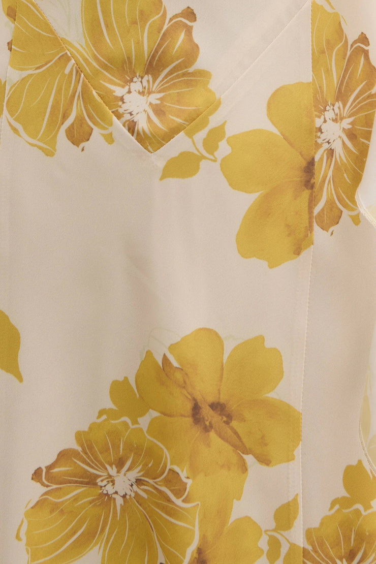 Close-up of a fabric with large yellow floral patterns on a beige background