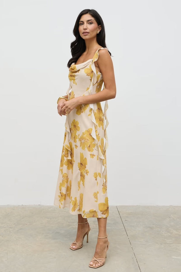 Woman wearing a yellow floral dress against a white background