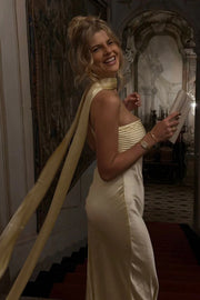 Woman in a white dress with a yellow ribbon in an ornate room