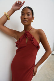 Woman wearing a red dress with ruffled details against a white background